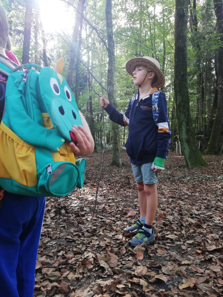 Ein Junge und ein Mädchen im Wald mit einem Gesicht einer Zeichentrickfigur