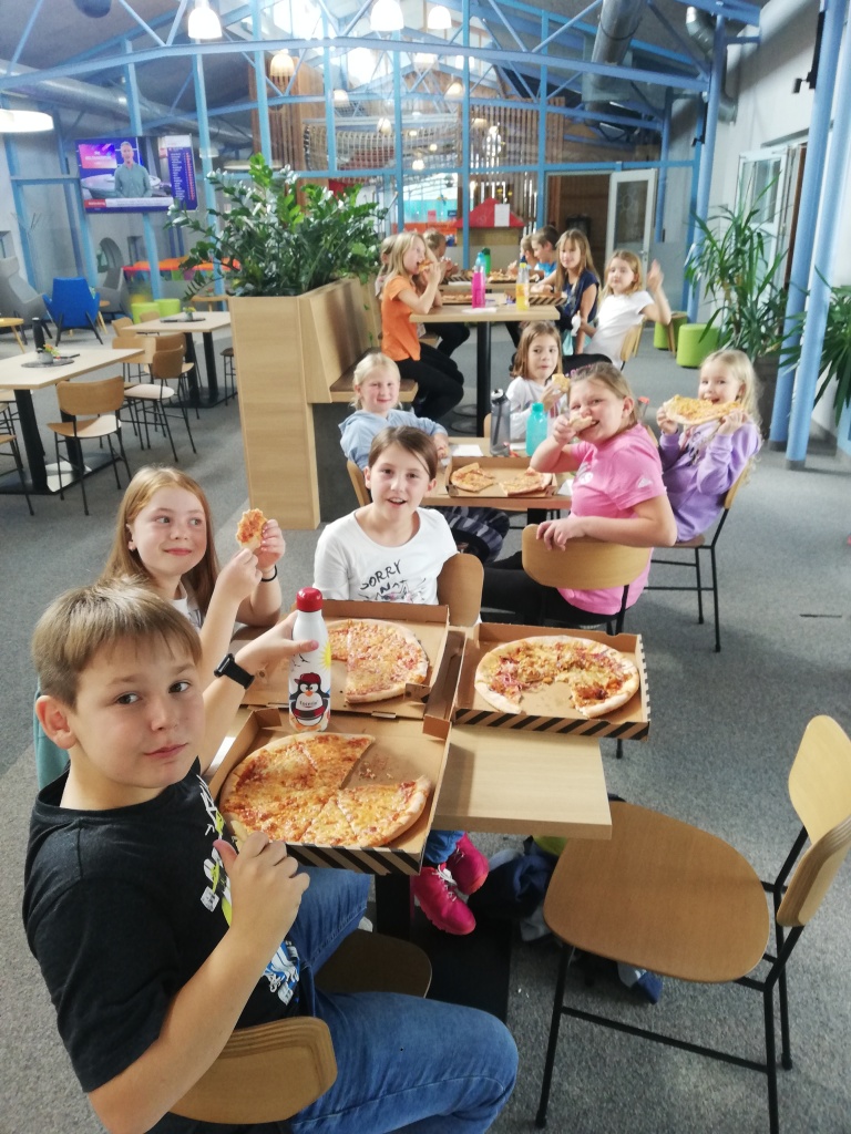 eine Gruppe von Kindern, die Pizza essen