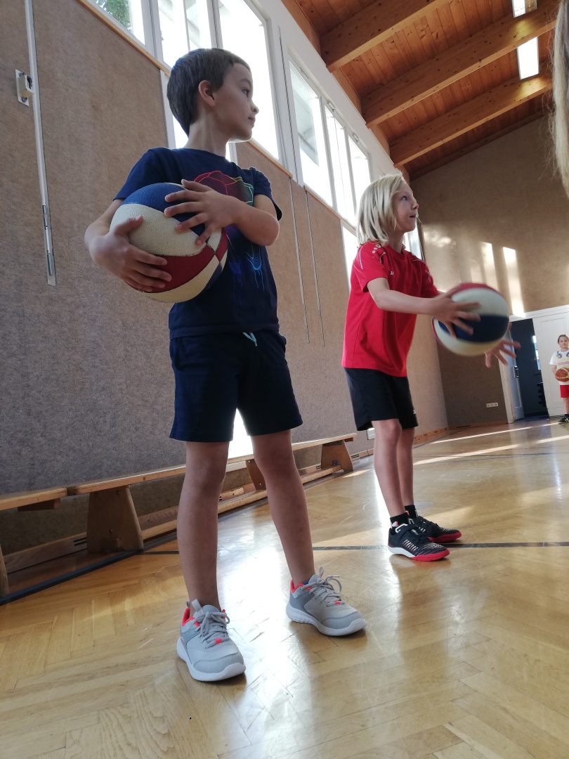 Ein Junge und ein Mädchen halten Basketbälle in der Hand